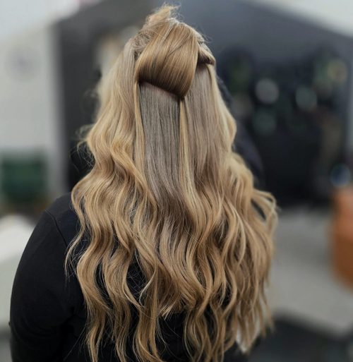 Extension wefts hidden under a half-up finish
